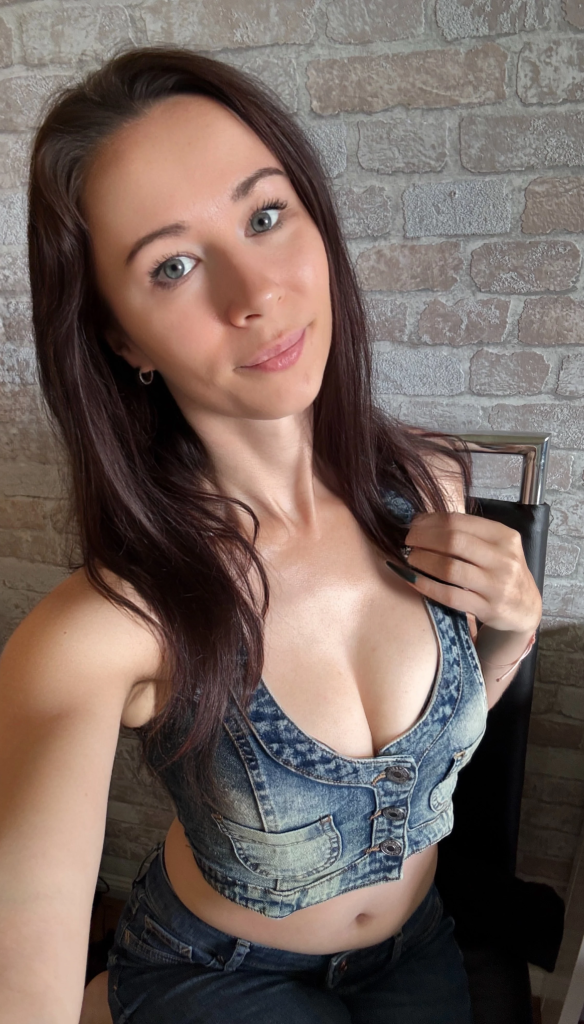 Ronya Rabe posiert im Jeans-Top und lächelt in die Kamera – authentisches Erotikmodel auf FansyMe.